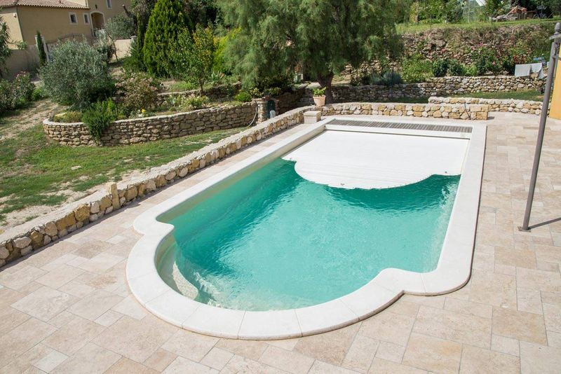 acheter une piscine coque polyester avec couverture automatique immergée caillebotis IPE bois